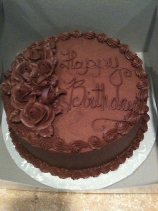 Chocolate birthday cake with piped chocolate roses and script lettering