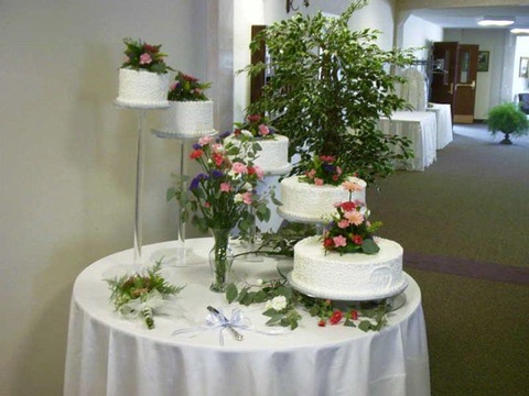 Wedding cakes on a fountain stand dressed with fresh pink flowers